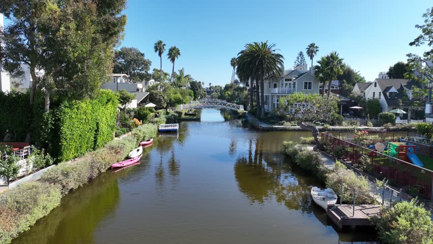 Venice Canal In Los Angeles California United States. Aerial View Of A River Surrounded By Lush Green Tropical Rainforest. Town Sky Backgrounds Urban. Town Outdoor Downtown Panning Wide.