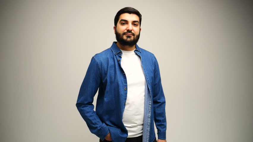Man stands proudly in a denim shirt, expression calm.	
