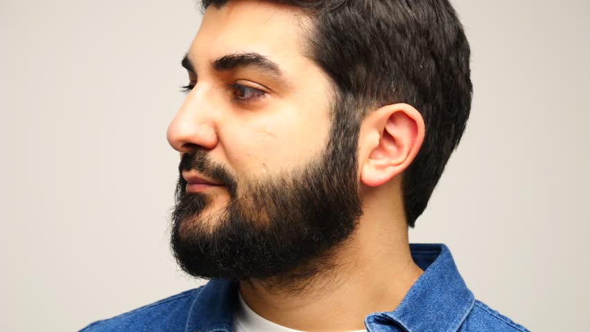 Smiling man in casual outfit poses with confidence against a clean white background