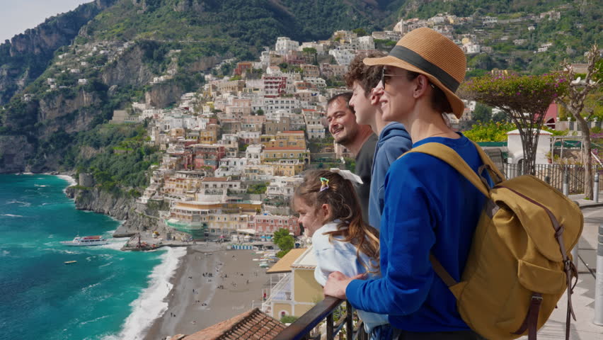 A family of four on holiday on the Amalfi Coast enjoy the views of the famous tourist town of Positano, Italy
