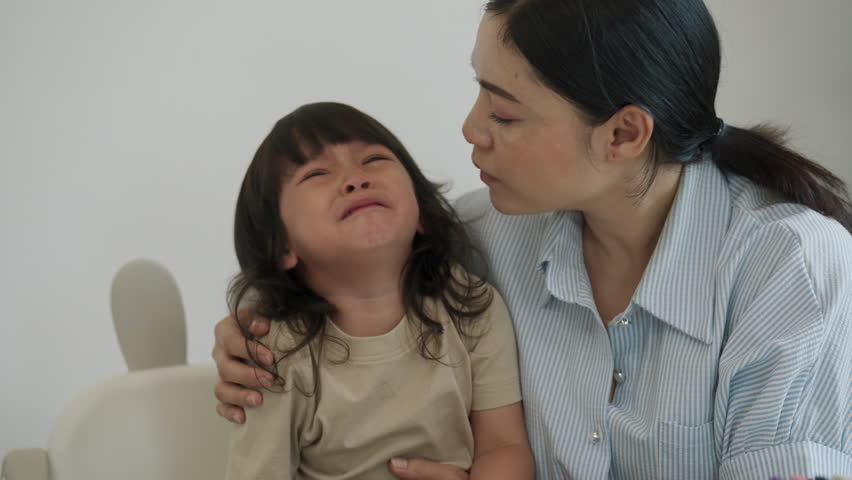 mother comforting her crying toddler girl
