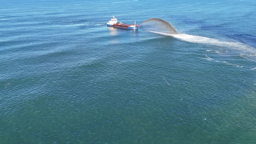 Aerial view of a dredging ship pumping sand into the ocean, addressing beach erosion on the Gold Coast, Australia