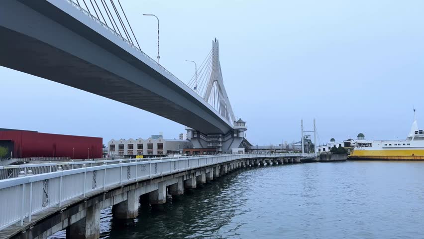 Large yellow ferry ship docked at Aomori Bay with a modern suspension bridge view