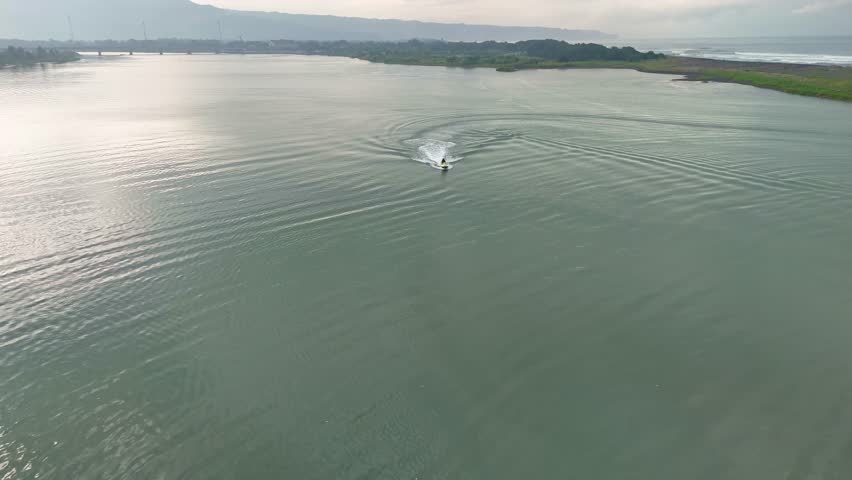 Aerial drone view of people riding a jet ski. Personal watercraft in calm beach.