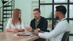 Young caucasian couple family consulting with professional indian doctor, discussing health concerns in bright, modern medical office during comprehensive wellness examination - Powered by Shutterstock - Get 15% off with code: PIKWIZARD15