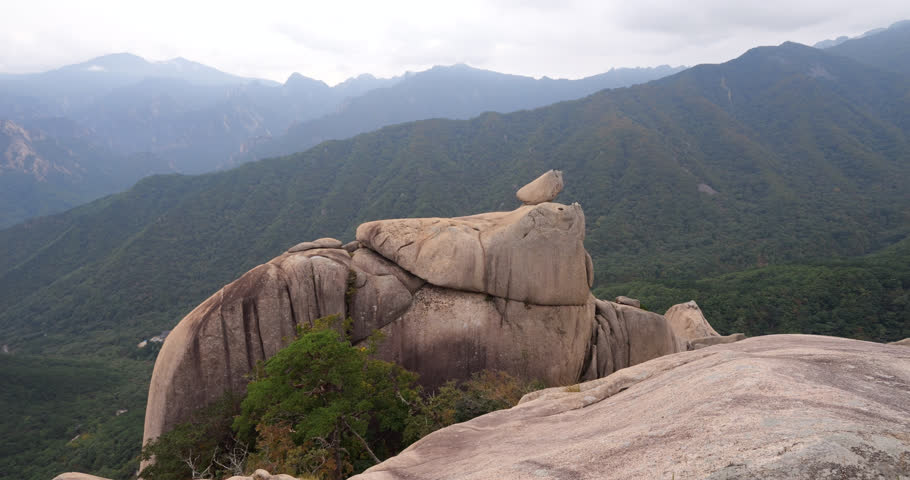 Ulsanbawi Rock Formation details at top, camera shows granite peak. Green mountains on background. Scenic views of Seoraksan National Park in South Korea.