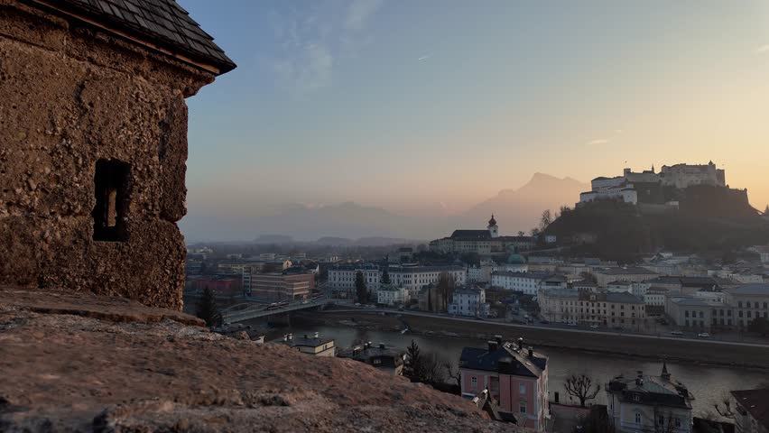 Salzburg, Austria: Dramatic sunset over Salzburg with the famous Fortress Hohensalzburg view from medieval old town Basteiweg wall. 
