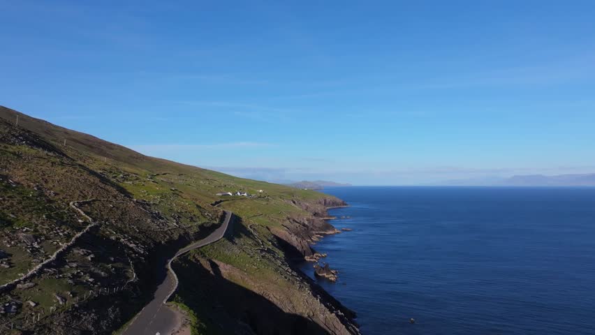 Iconic Slea Head coastline glowing in bright sunlight and deep blue skies - Dingle Co.Kerry - 4K Cinematic Drone Footage 01.