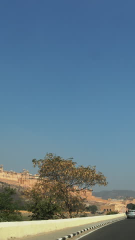 Amer, Rajasthan, India. Indian camel drivers lead camels along a busy highway.