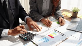 Young colleagues discuss business and analytical price charts using calculators and laptops to calculate financial, tax, accounting, statistics and analytical research ideas. - Powered by Shutterstock - Get 15% off with code: PIKWIZARD15