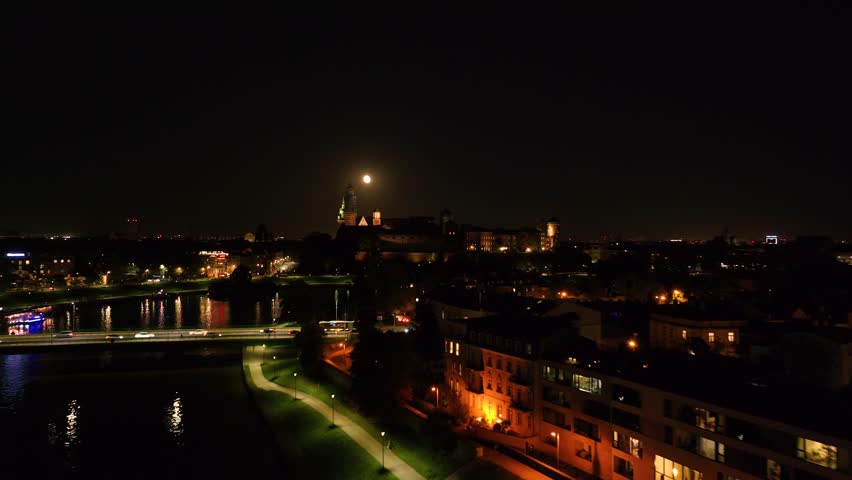 Moonlit wawel castle reflections over vistula river in krakow at night