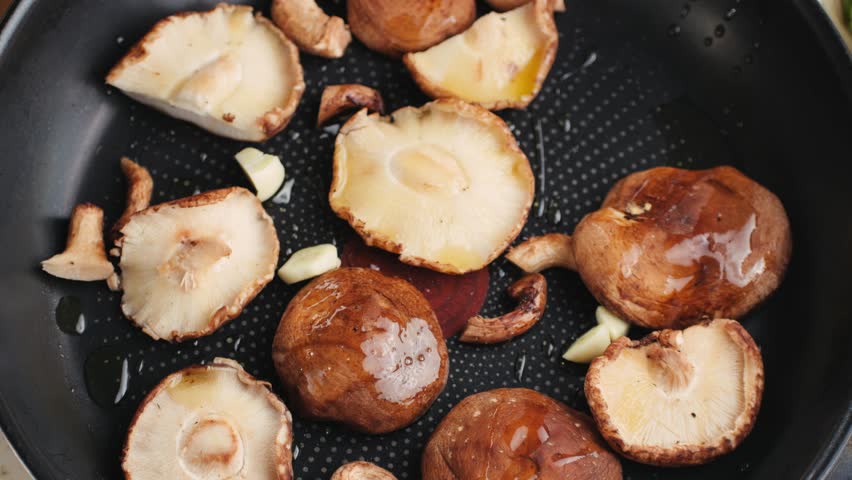 Fresh Royal oyster mushrooms, chef cooking on a wooden cutting board with knife in cafe asian restaurant kitchen, vibrant scene of food preparation