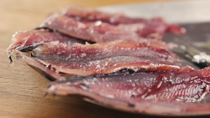 Chef cooking Fresh Sea sardines and Anchovy Fish and Mullus, salted fermented fish, On Display On Ice On Market Store Shop. Seafood Fish Background, sprats, smelt close up stand of small salty white
