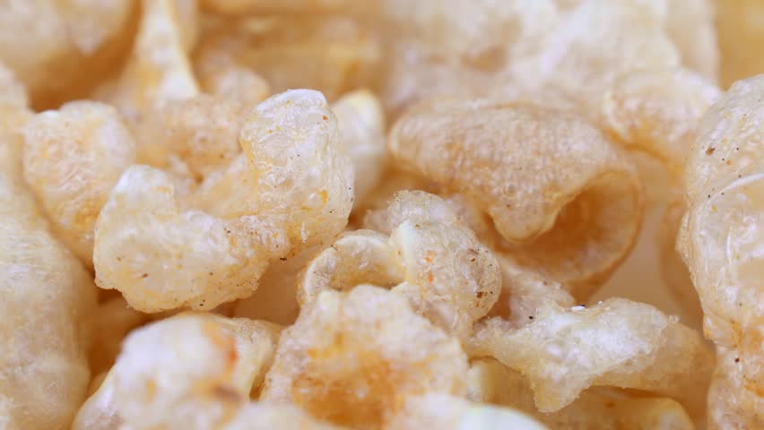 Deep fried chicharron or chicharrones pork rinds circle rotation close up
