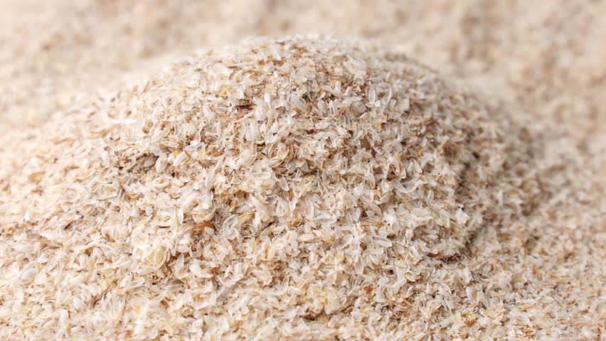 Psyllium husk (Ispaghula) falling down close up. Dietary fiber product