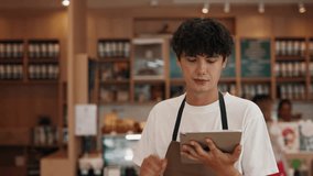 Portrait of attentive male server taking order with tablet computer in cafe. Young man uses digital menu working with guests in restaurant. Positive guy cafeteria employee - Powered by Shutterstock - Get 15% off with code: PIKWIZARD15