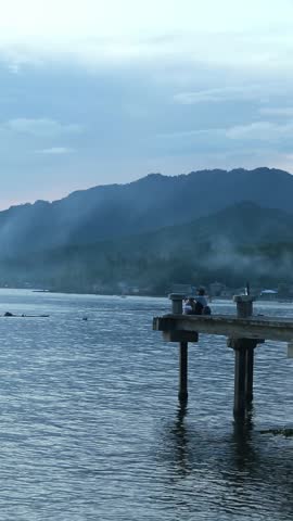 Fisherman Sitting on Pier During Sunset
