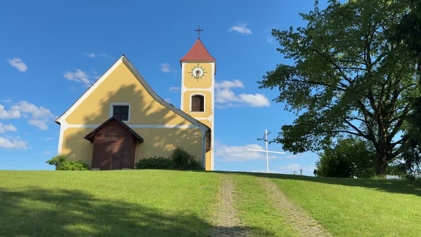 romantic church on hill with white cross in Austria