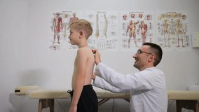A skilled doctor is examining a young child with anatomical charts in the background - Powered by Shutterstock - Get 15% off with code: PIKWIZARD15