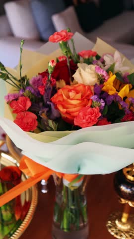 Platters of traditional arabic sweets and an assortment of flowers take center stage at a lively gathering, creating a festive atmosphere, ready to celebrate the end of Ramadan. 4K footage, handheld s