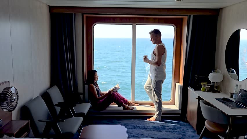 Enjoy a tranquil moment aboard a cruise ship with breathtaking ocean views of the Faroe Islands. A couple unwinds while sipping coffee and reading, surrounded by comfort and serenity.
