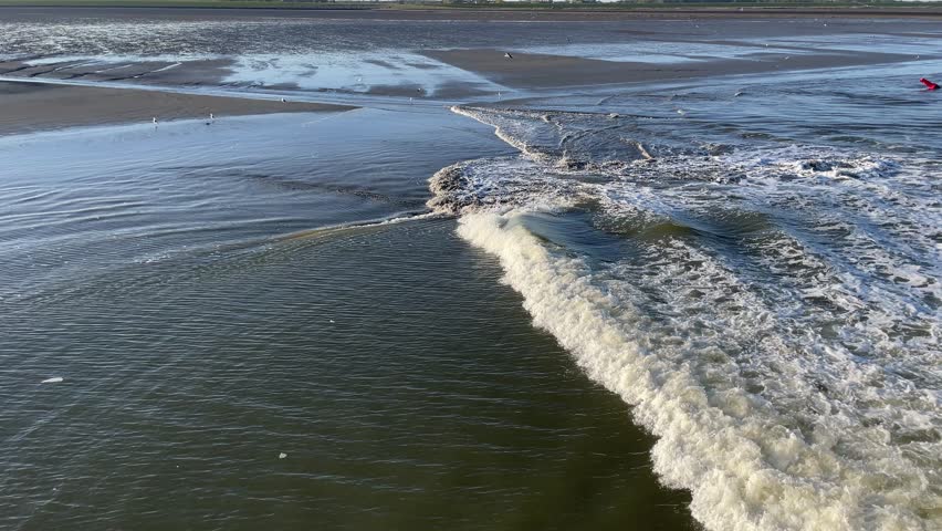 Wadden Sea at Low Tide Seen from Ferry – Waves Flow Across Exposed Mudflats
