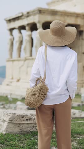 Traveler fahion woman with hat sightseeing the statues at the Porch of the Caryatids at Erechtheion, Acropolis in Athens, Greece
