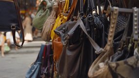 Various leather hand bags hanging outside in street market stall in Europe. Close up on boutique and hand made fashion handbags and totes made in Italy and sold at fairs and markets shops and booths - Powered by Shutterstock - Get 15% off with code: PIKWIZARD15