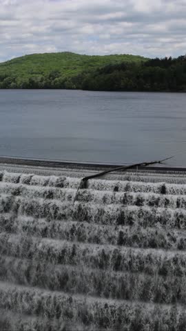 water cascading down waterfall at croton dam (man made and natural drinking water reservoir) westchester new york landmark with old bridge (tourism travel hiking destination) nature landscape