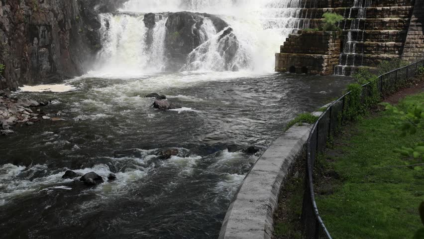 water cascading down waterfall at croton dam (man made and natural drinking water reservoir) westchester new york landmark with old bridge (tourism travel hiking destination) nature landscape