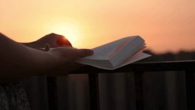 Woman Reading Book at Sunset on Balcony - Powered by Shutterstock - Get 15% off with code: PIKWIZARD15