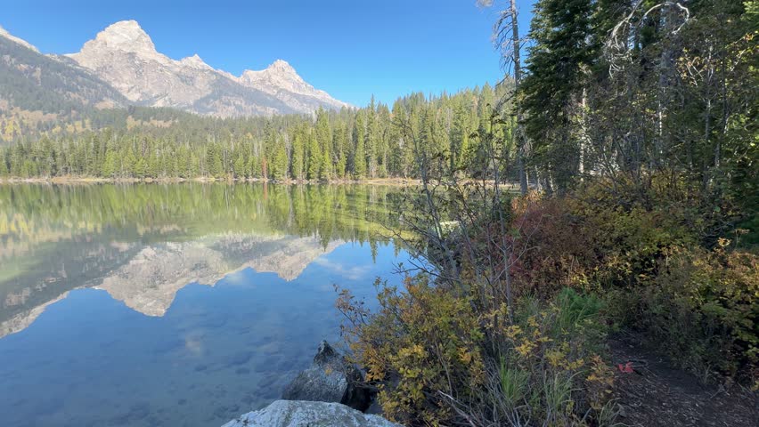 Perfect autumn morning in Grand Teton National Park with the mountains reflecting in the alpine lake