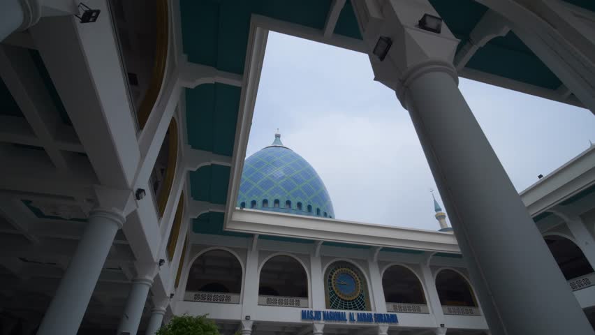 The blue circular dome of al-Akbar National Mosque Surabaya in Southeast Asia, Indonesia. The text translation that appears in the picture: al-Akbar National Mosque Surabaya.