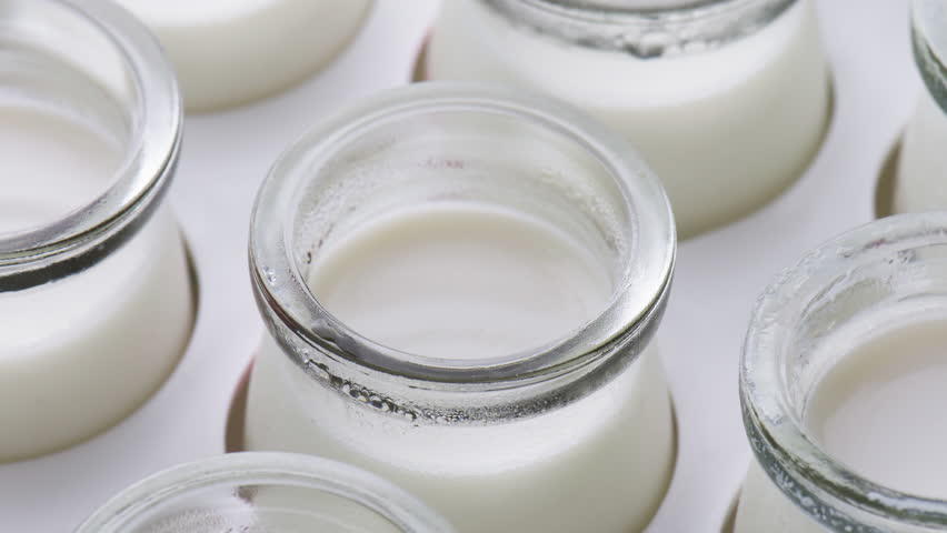 Homemade yogurt. Macro shot. Closeup view of small jars with freshly prepared yogurt. Healthy eco food.