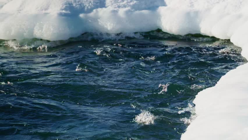 Experience the mesmerizing flow of a winter river, gracefully winding through the landscape, surrounded by stunning glistening ice formations, truly showcasing natures beauty and its movement