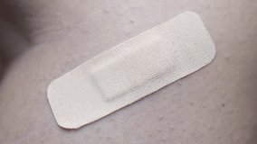 Closeup view of removing an adhesive plaster from a wound. First aid concept. Health care. - Powered by Shutterstock - Get 15% off with code: PIKWIZARD15