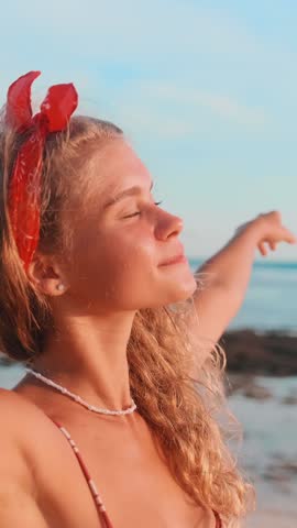 A young woman cherishes romantic getaway at the beach, soaking in the sun and ocean waves. Her laughter and happiness create unforgettable memories as she embraces nature's serenity.