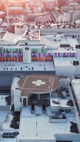 Landing pad for rescue helicopter on the roof of a hospital complex. Orbiting drone shot