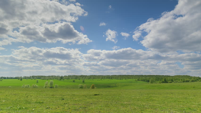 A Lush Green Meadow Beautifully Positioned Under a Cloudy and Overcast Sky Expansively Time lapse.