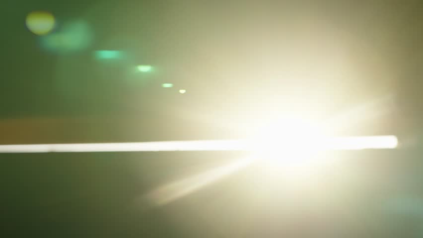Warm sunlight streaming through dark room window, revealing dancing dust particles and creating ethereal lens flare effects with soft illumination