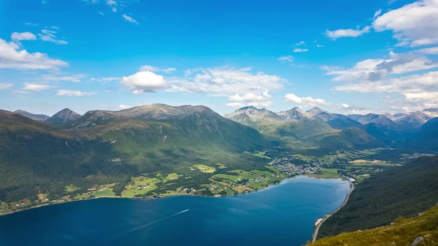 Timelapse of moving clouds viewed from Nesaksla mountain above Isfjorden village and Romsdalsfjorden with surrounding valleys and peaks in Norway. 4K UHD video.