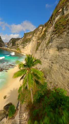Cinematic FPV drone flight over iconic Diamond Beach with limestone cliffs, turquoise ocean, and white sand on Nusa Penida Island, Bali, Indonesia.