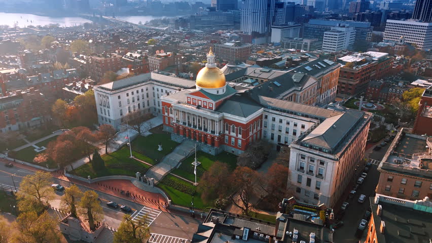 Flight around the beautiful building of Massachusetts State House in Boston. The Charles River shining in the sun at backdrop.