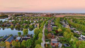Flight over the village located on the water. Beautiful picturesque countryside with lush greenery at sunset time. Aerial view. Vinkeveen, the Netherlands. - Powered by Shutterstock - Get 15% off with code: PIKWIZARD15