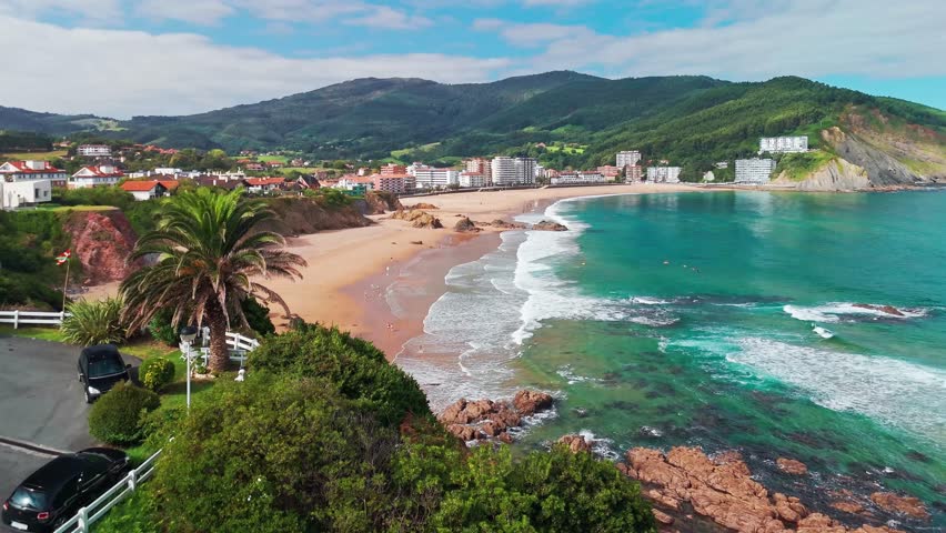 Beautiful Bakio Hondartza beach in Bentalde, Bakio, Basque Country, Spain. A group of surfers catching waves on the stunning sandy beach in northern Spain