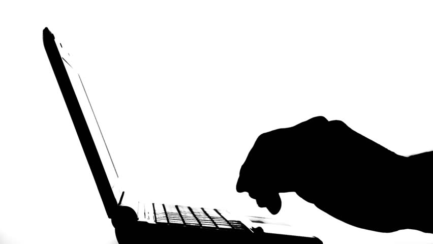 Typing on laptop quickly. Backlight. Silhouette of a laptop and man's hands