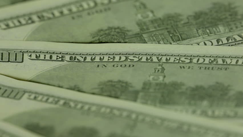 Several hundred-dollar bills spinning. A narrow strip of focus - only 
