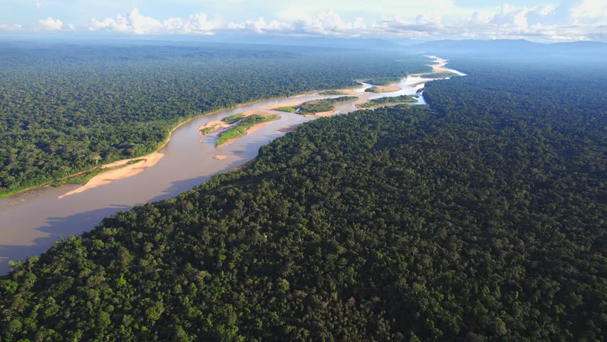 Aerial view reveals Peru’s mighty Amazon winding through endless stretches of lush green rainforest. Tambopata reserve