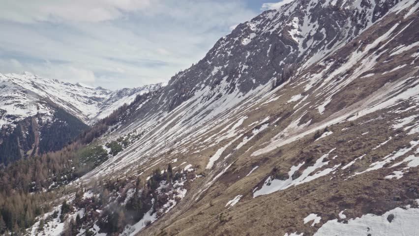 Snowy mountain landscape showing melting snow in spring