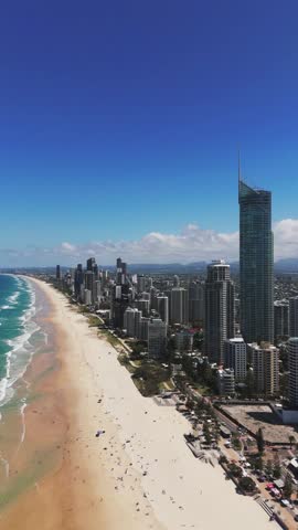 Vertical, aerial: Surfers Paradise in Queensland, a seaside resort and tourism centre district in the City of Gold Coast, Queensland, Australia, pull out drone shot